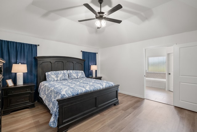 bedroom with connected bathroom, ceiling fan, lofted ceiling, and light wood-type flooring