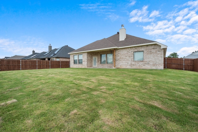 rear view of house featuring a lawn