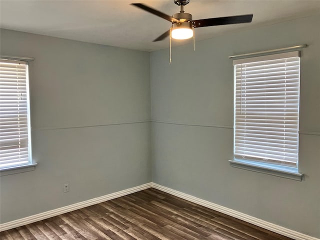 empty room with ceiling fan, a healthy amount of sunlight, and dark hardwood / wood-style flooring