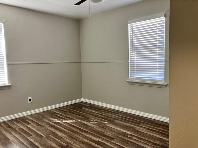 unfurnished room featuring a healthy amount of sunlight, dark hardwood / wood-style floors, and ceiling fan