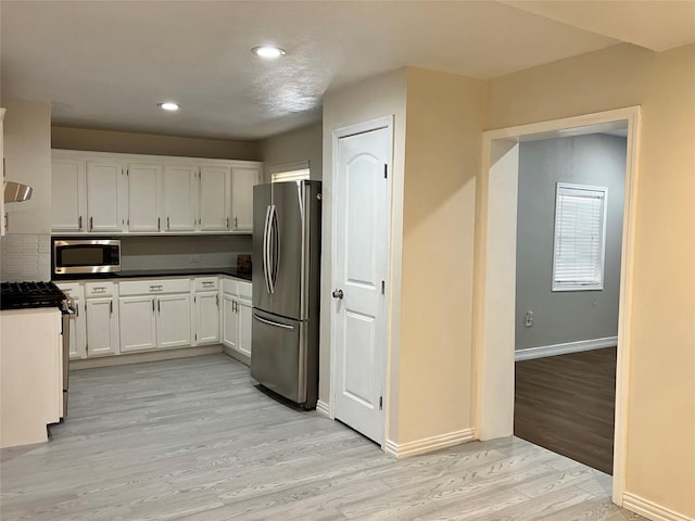 kitchen with white cabinetry, light hardwood / wood-style flooring, and stainless steel appliances