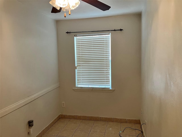 empty room featuring a healthy amount of sunlight, light tile patterned floors, and ceiling fan