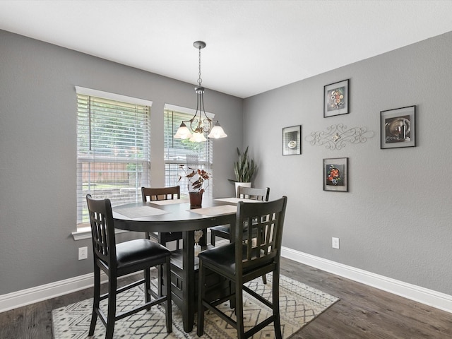 dining space featuring dark hardwood / wood-style flooring, a wealth of natural light, and a chandelier