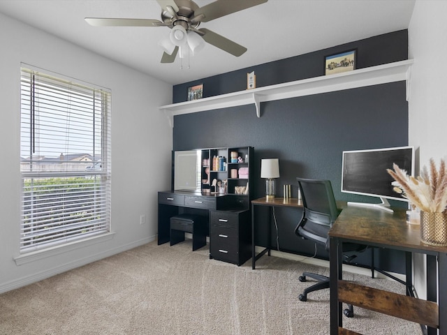 carpeted office space featuring ceiling fan and a healthy amount of sunlight