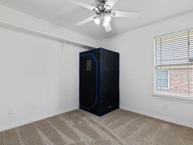 interior space with carpet flooring and ceiling fan