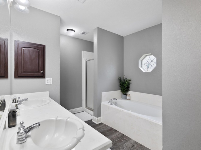 bathroom with hardwood / wood-style floors, vanity, and shower with separate bathtub