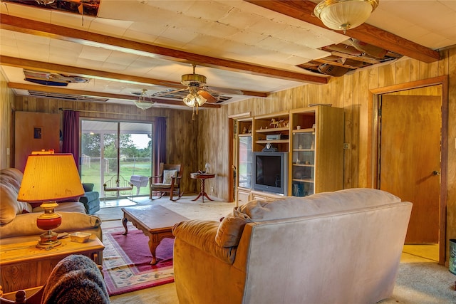 carpeted living room featuring beamed ceiling, wooden walls, and ceiling fan