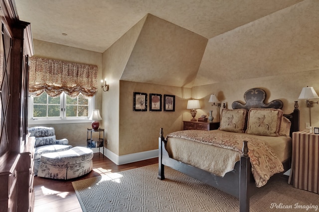 bedroom with hardwood / wood-style floors and lofted ceiling