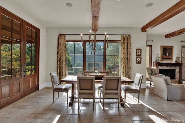 tiled dining space with a chandelier, beam ceiling, and french doors