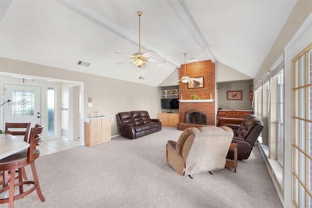 living room with vaulted ceiling with beams, ceiling fan, light colored carpet, and a brick fireplace