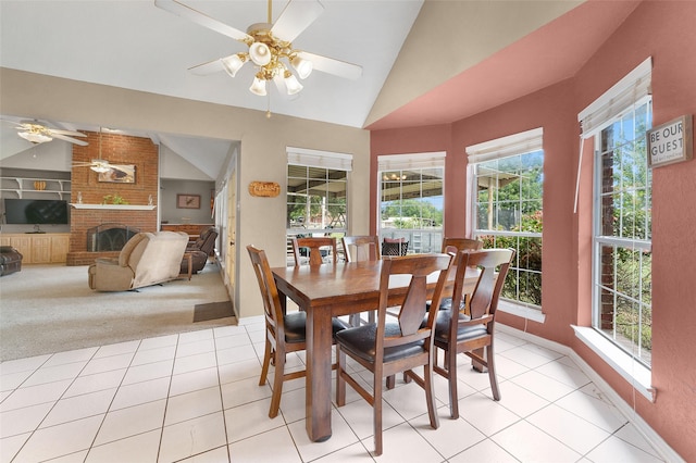 tiled dining room featuring ceiling fan, lofted ceiling, built in shelves, and a brick fireplace