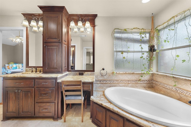 bathroom with a bath, vanity, and ceiling fan