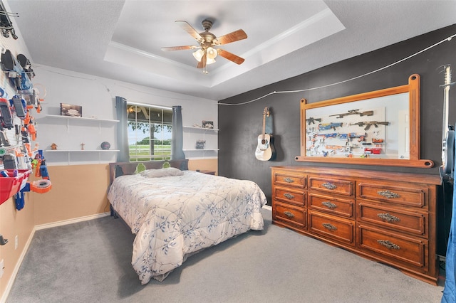 carpeted bedroom with a tray ceiling and ceiling fan