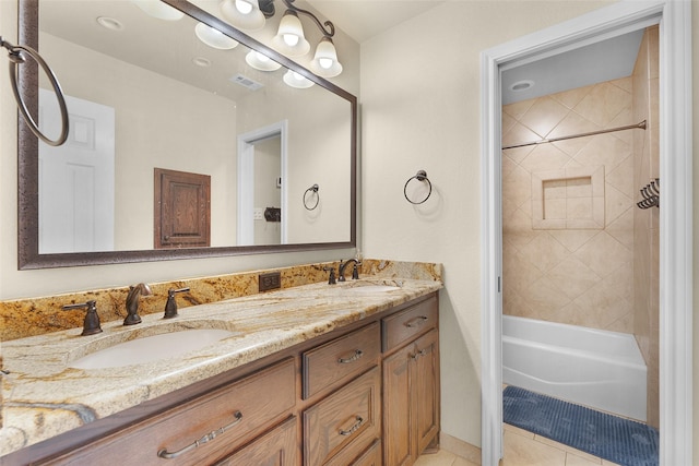 bathroom with tile patterned floors, vanity, and tiled shower / bath combo