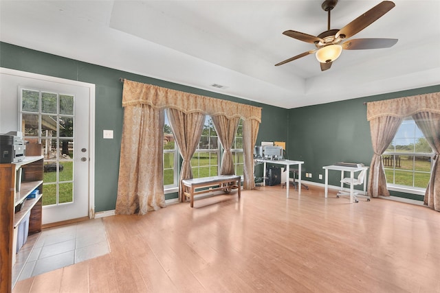 misc room with a raised ceiling, ceiling fan, plenty of natural light, and hardwood / wood-style flooring