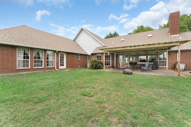 rear view of house featuring a yard and a patio