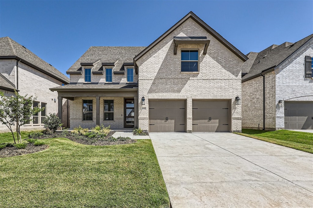 view of front of house featuring a front yard, a porch, and a garage