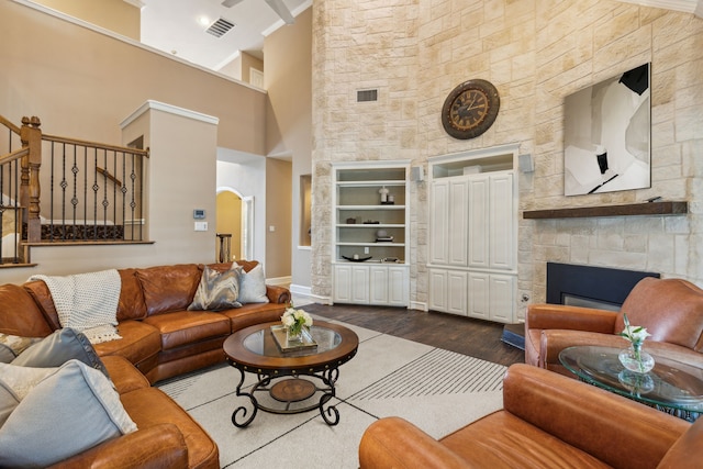 living room with a fireplace, dark hardwood / wood-style flooring, and a high ceiling