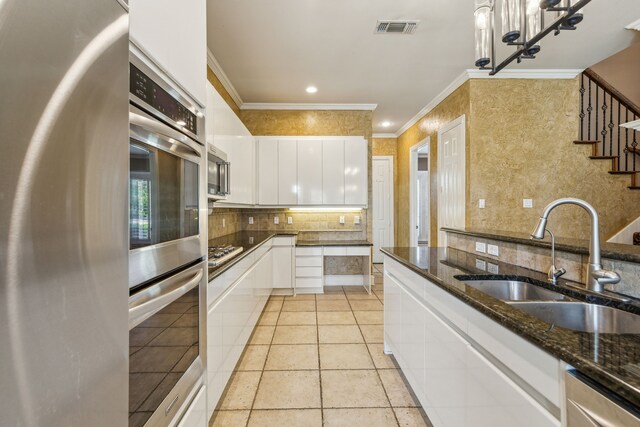 kitchen featuring ornamental molding, ornate columns, pendant lighting, and sink