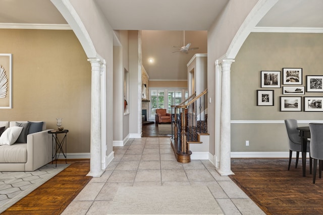 tiled foyer entrance with ornate columns, ceiling fan, and crown molding