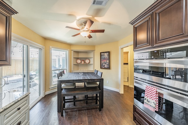 kitchen featuring dark brown cabinetry, dark hardwood / wood-style floors, ceiling fan, tasteful backsplash, and stainless steel double oven