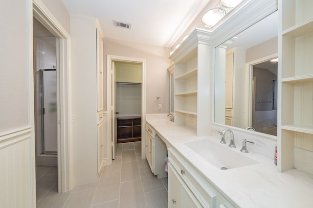 bathroom featuring tile floors, a shower with door, and vanity