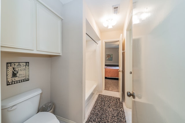 bathroom featuring tile flooring, toilet, and tub / shower combination