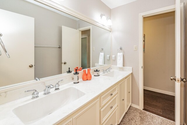 bathroom with wood-type flooring, large vanity, and double sink