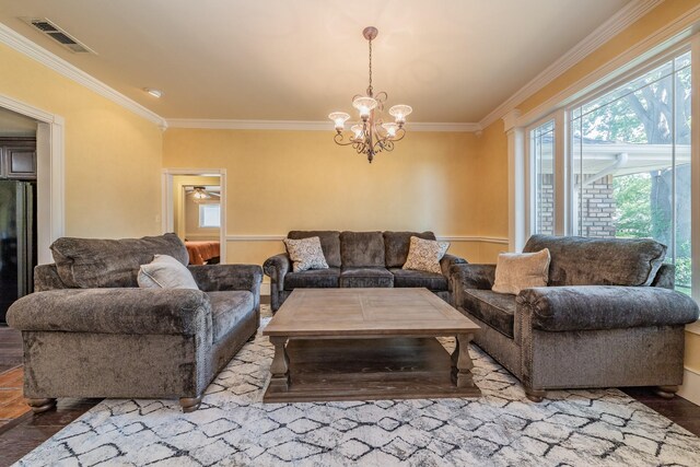 living room with wood-type flooring, an inviting chandelier, and ornamental molding