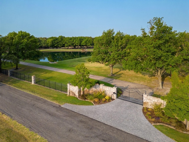 view of community featuring a lawn and a water view