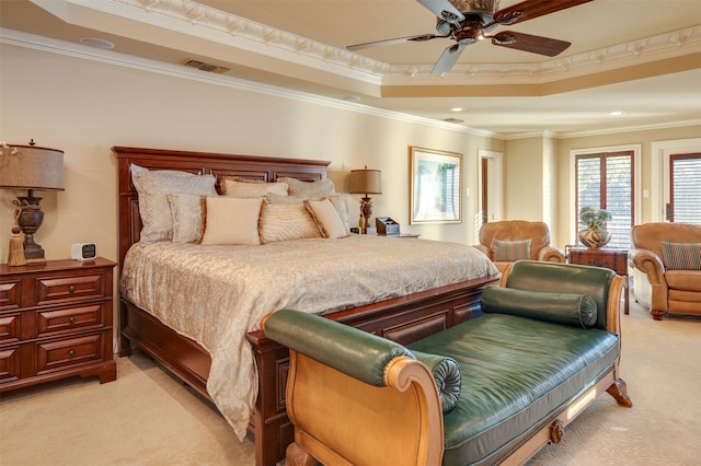 carpeted bedroom featuring ceiling fan, ornamental molding, and a tray ceiling