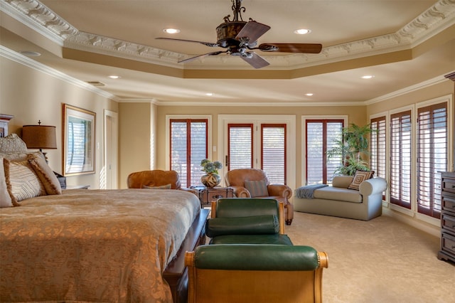 bedroom featuring ceiling fan, crown molding, light carpet, and a tray ceiling