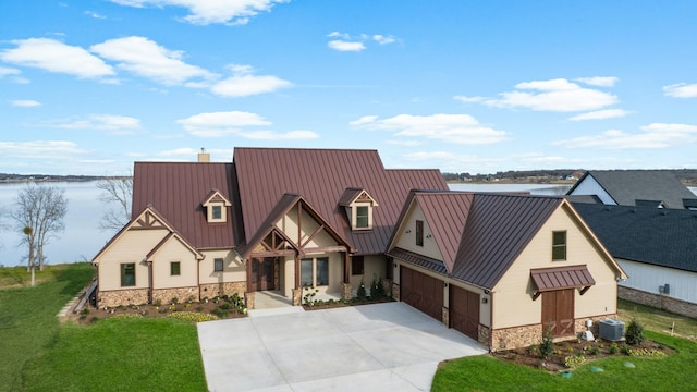 modern farmhouse style home featuring a garage, a standing seam roof, metal roof, and stone siding
