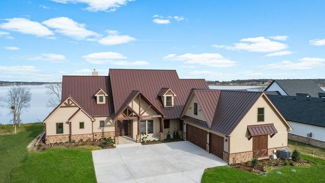 view of front of home featuring a garage, a front lawn, a water view, and central AC unit