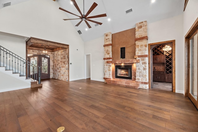 unfurnished living room featuring high vaulted ceiling, ceiling fan, visible vents, stairway, and dark wood-style floors