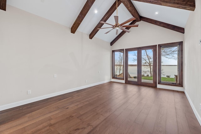 unfurnished living room featuring plenty of natural light, dark wood-type flooring, high vaulted ceiling, and beam ceiling