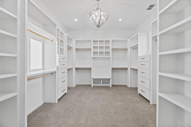 spacious closet with light colored carpet and a chandelier