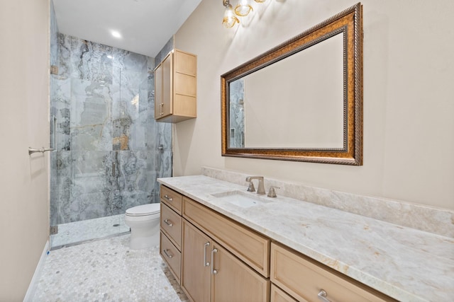 bathroom with toilet, tiled shower, and vanity