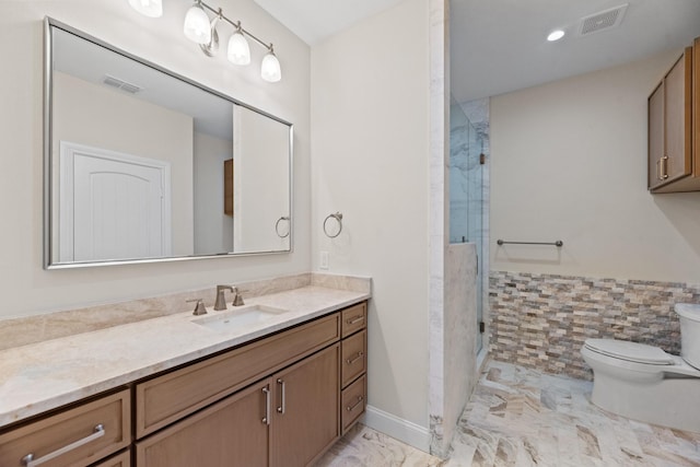 bathroom with a shower with shower door, toilet, and vanity