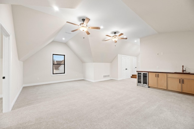 bonus room featuring sink, wine cooler, light carpet, and lofted ceiling