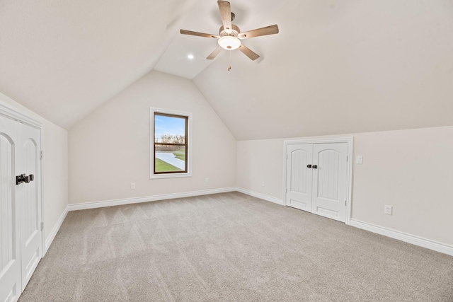 bonus room featuring ceiling fan, light colored carpet, and lofted ceiling