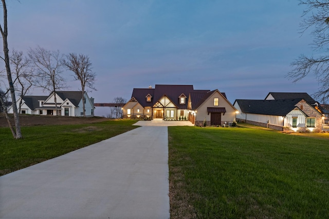 modern farmhouse style home featuring concrete driveway, a front yard, and metal roof