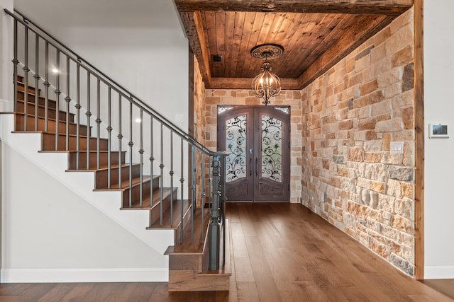 foyer with wood ceiling, stairs, french doors, wood-type flooring, and baseboards