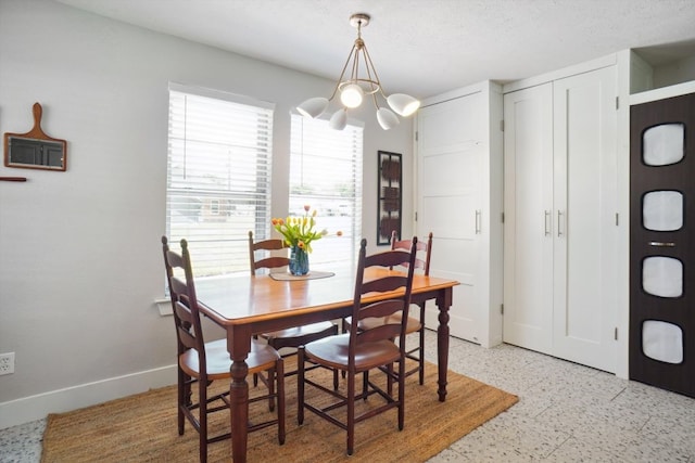 dining space featuring a notable chandelier, a textured ceiling, and light tile flooring