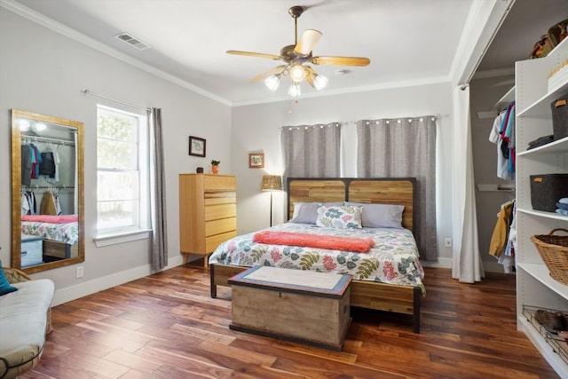 bedroom featuring dark hardwood / wood-style flooring, ceiling fan, crown molding, and multiple windows