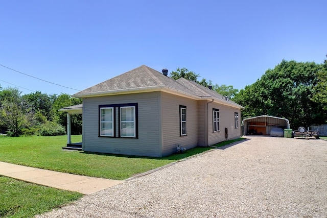 view of front of property featuring an outdoor structure, a front lawn, and a garage