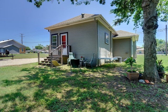 back of house featuring a lawn