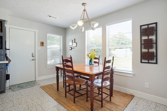 tiled dining area featuring a chandelier