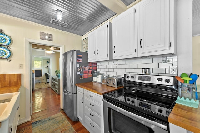 kitchen with appliances with stainless steel finishes, butcher block counters, visible vents, and white cabinetry