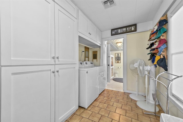 laundry room featuring cabinet space, light tile patterned floors, visible vents, and washer and clothes dryer